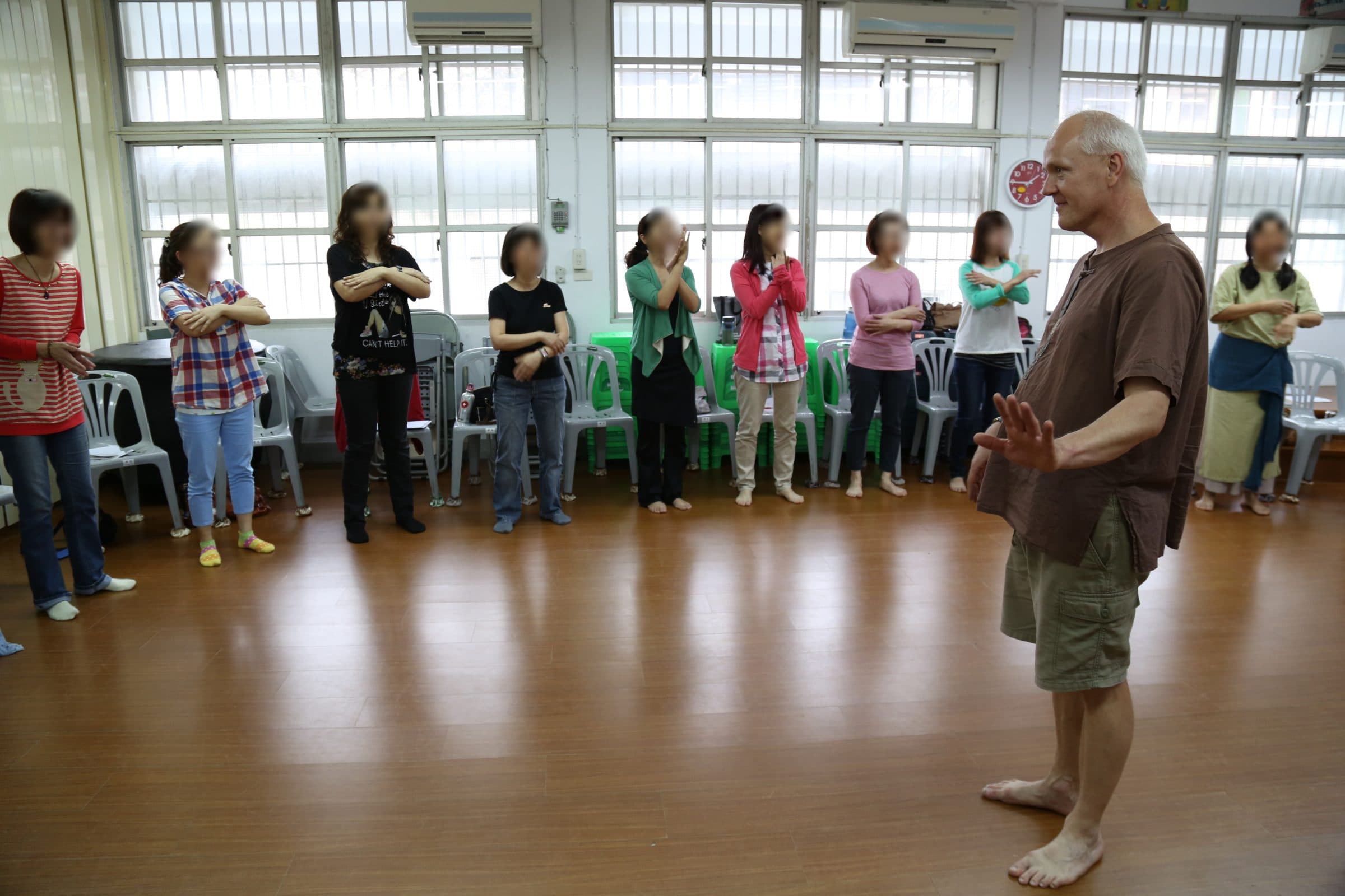 Workshop participants standing in a circle during a body percussion exercise